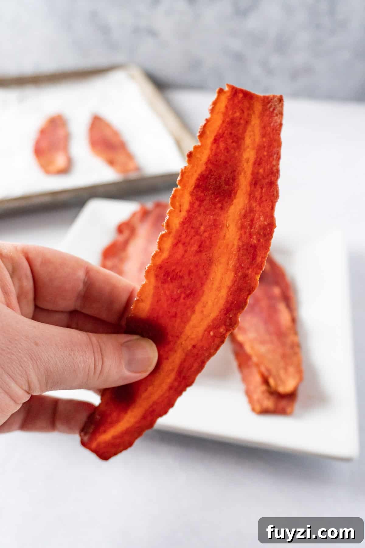Crispy Oven-Baked Turkey Bacon 6 holding turkey bacon in hand
