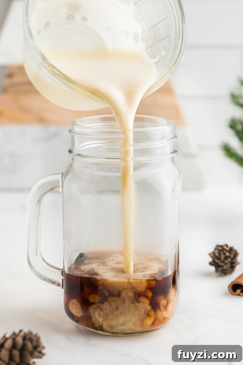 Foamy eggnog being poured over espresso.
