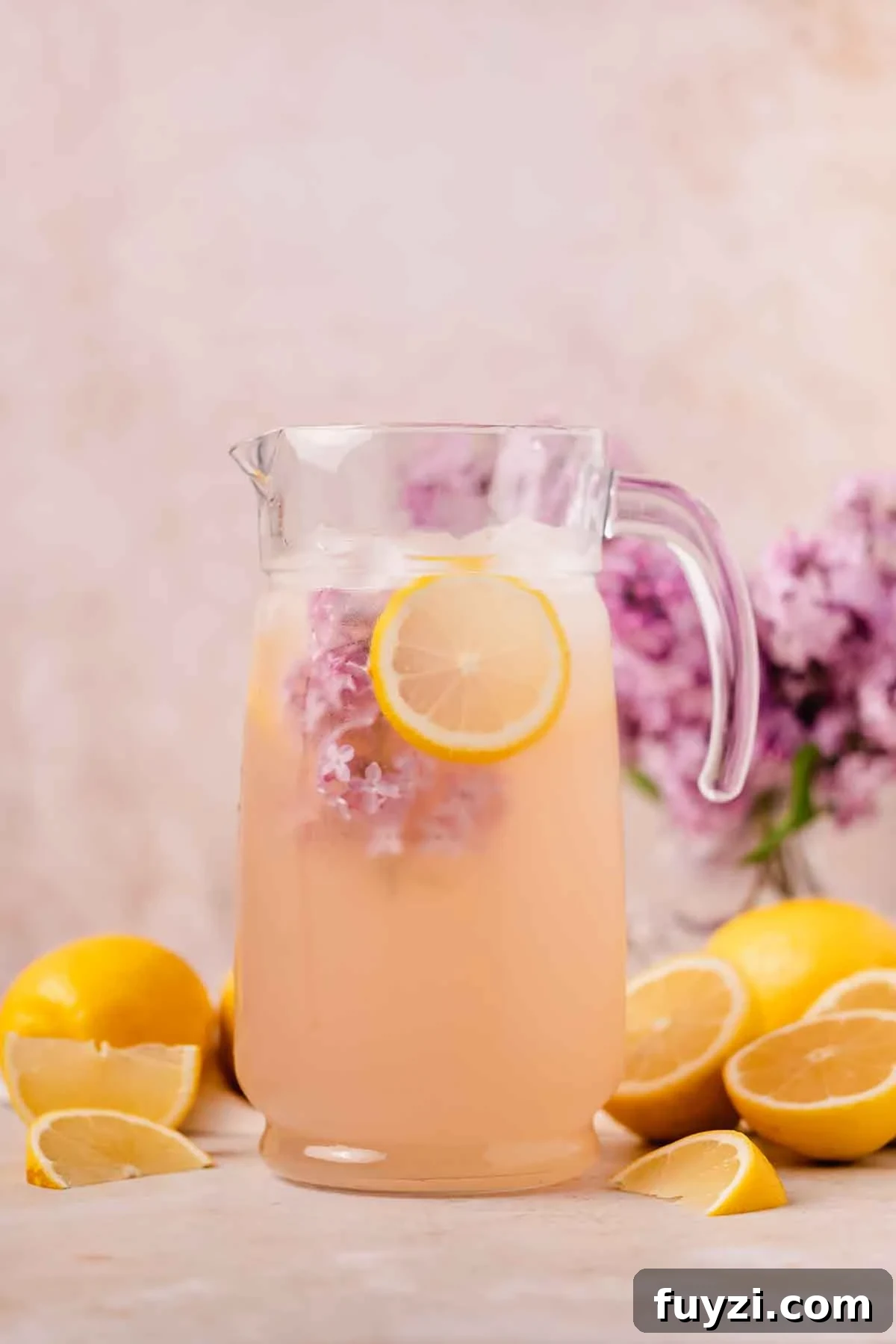 Lilac Lemonade Recipe: How to Make a Floral Citrus Drink 2 pitcher full of lemonade with lilacs and lemon slice