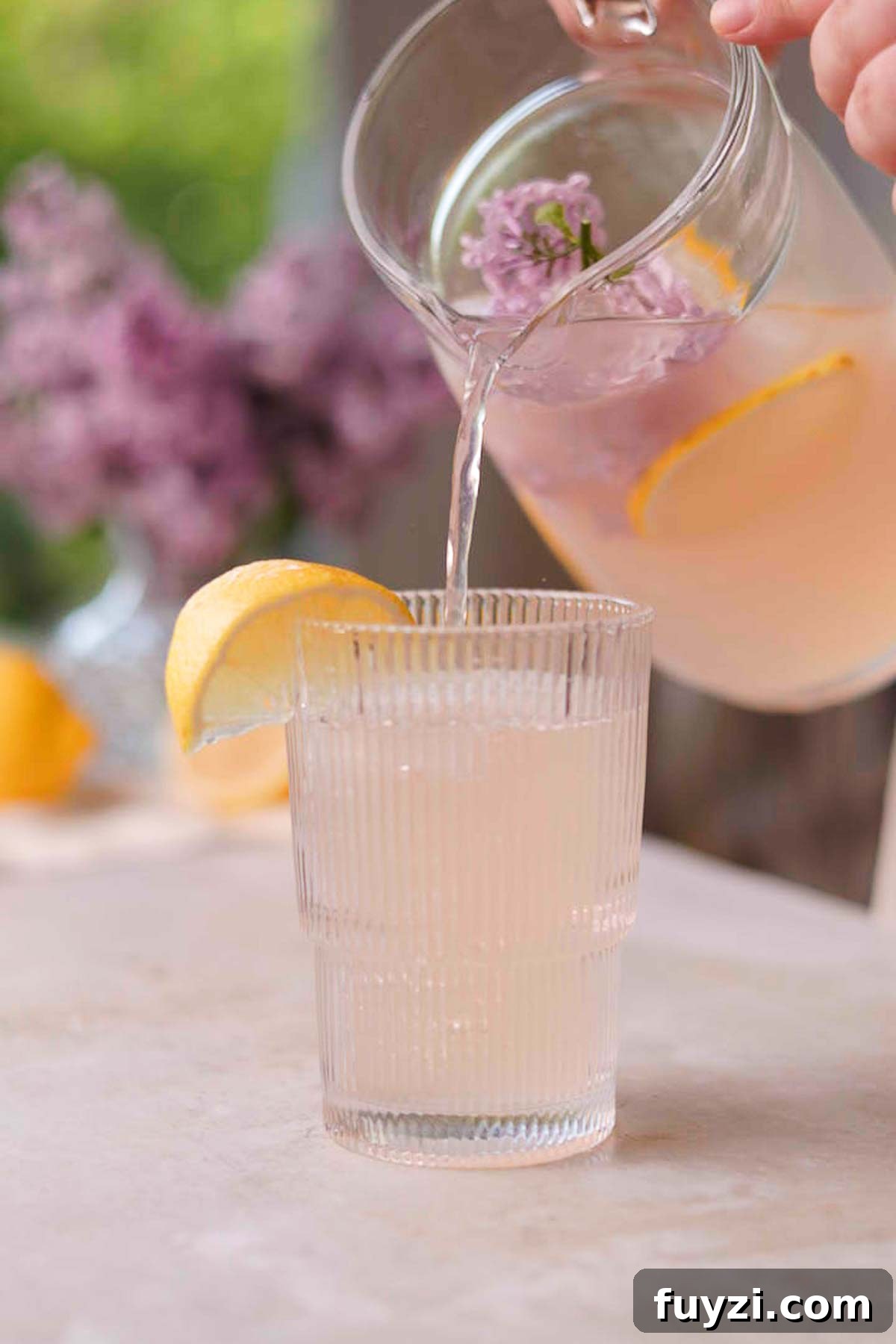 Lilac Lemonade Recipe: How to Make a Floral Citrus Drink 12 pouring lilac lemonade into a glass