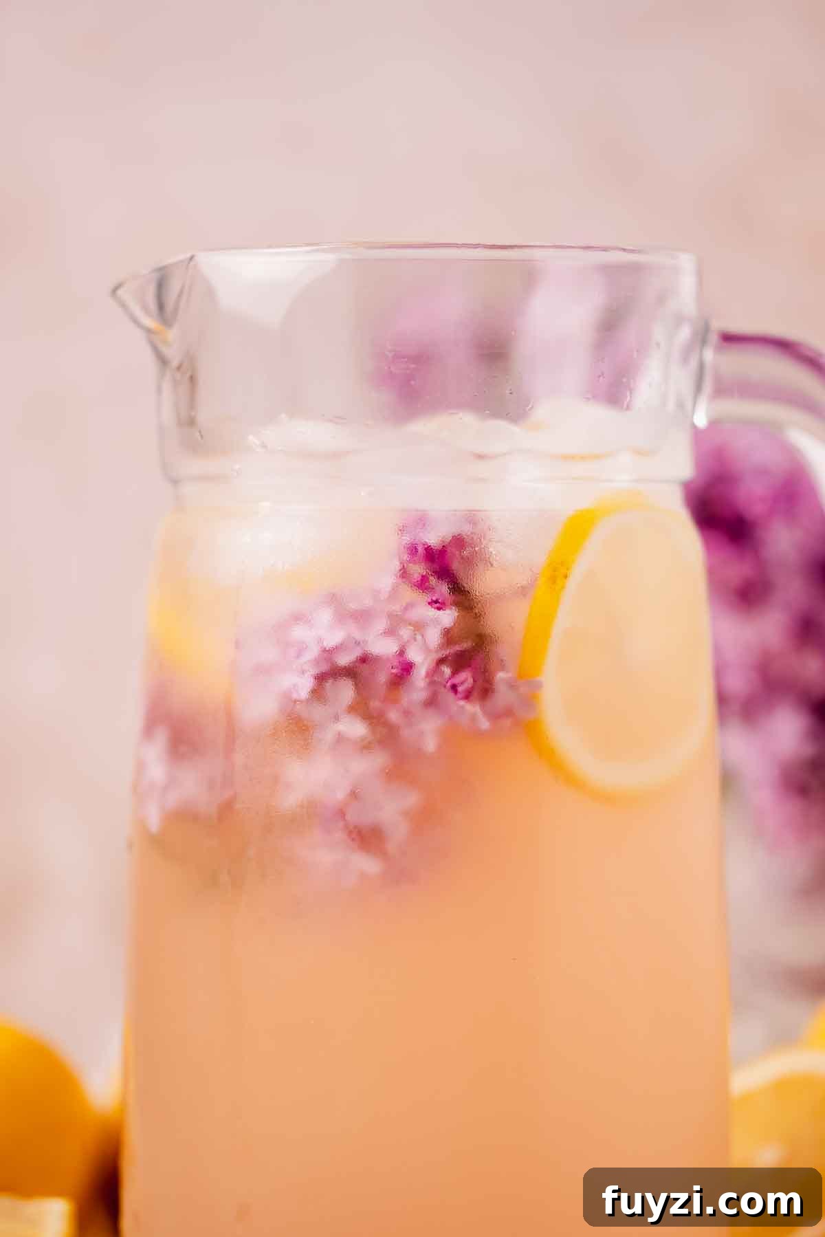 Lilac Lemonade Recipe: How to Make a Floral Citrus Drink 13 closeup of lilac lemonade in pitcher with lilac blossoms