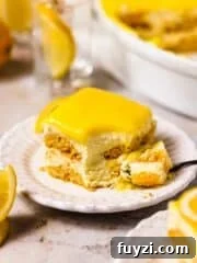 slice of creamy lemon tiramisu on white plate topped with lemon curd