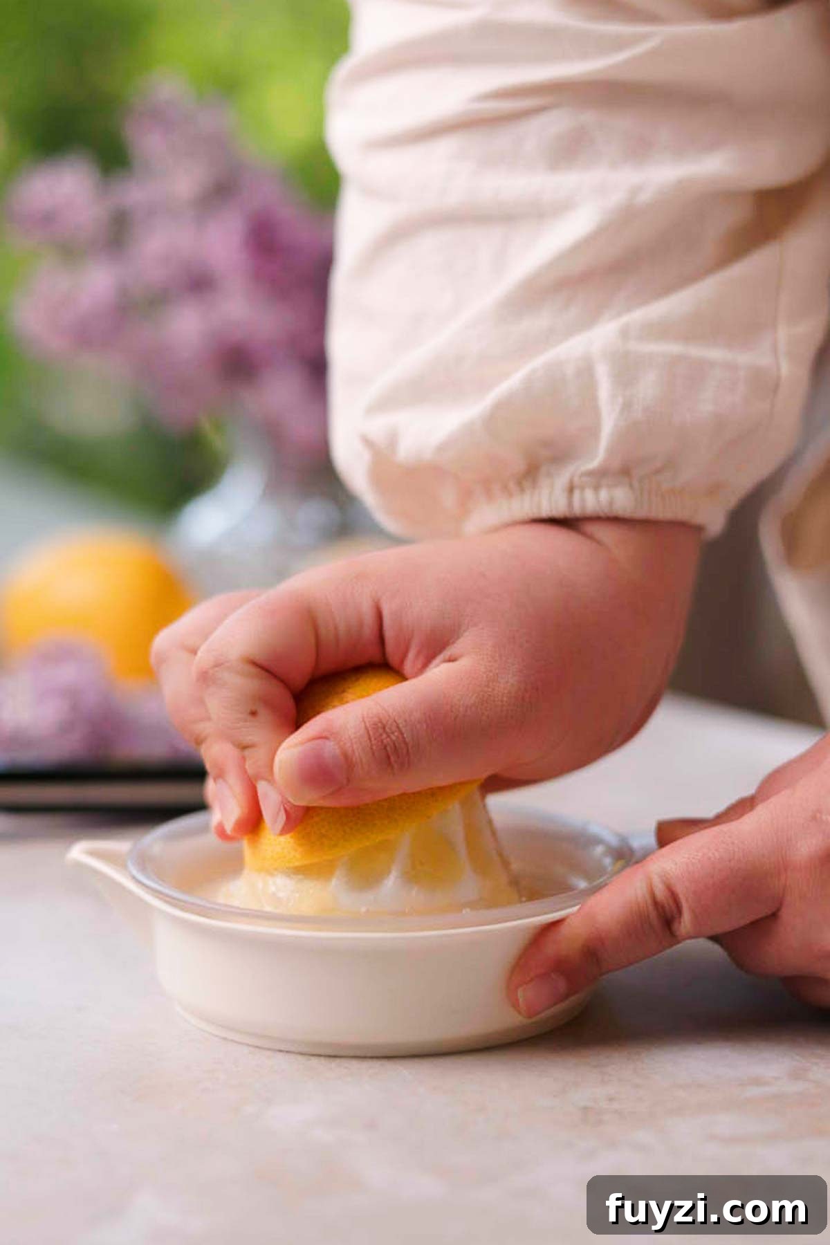 Lilac Lemonade Recipe: How to Make a Floral Citrus Drink 9 squeezing lemon half with a lemon squeezer