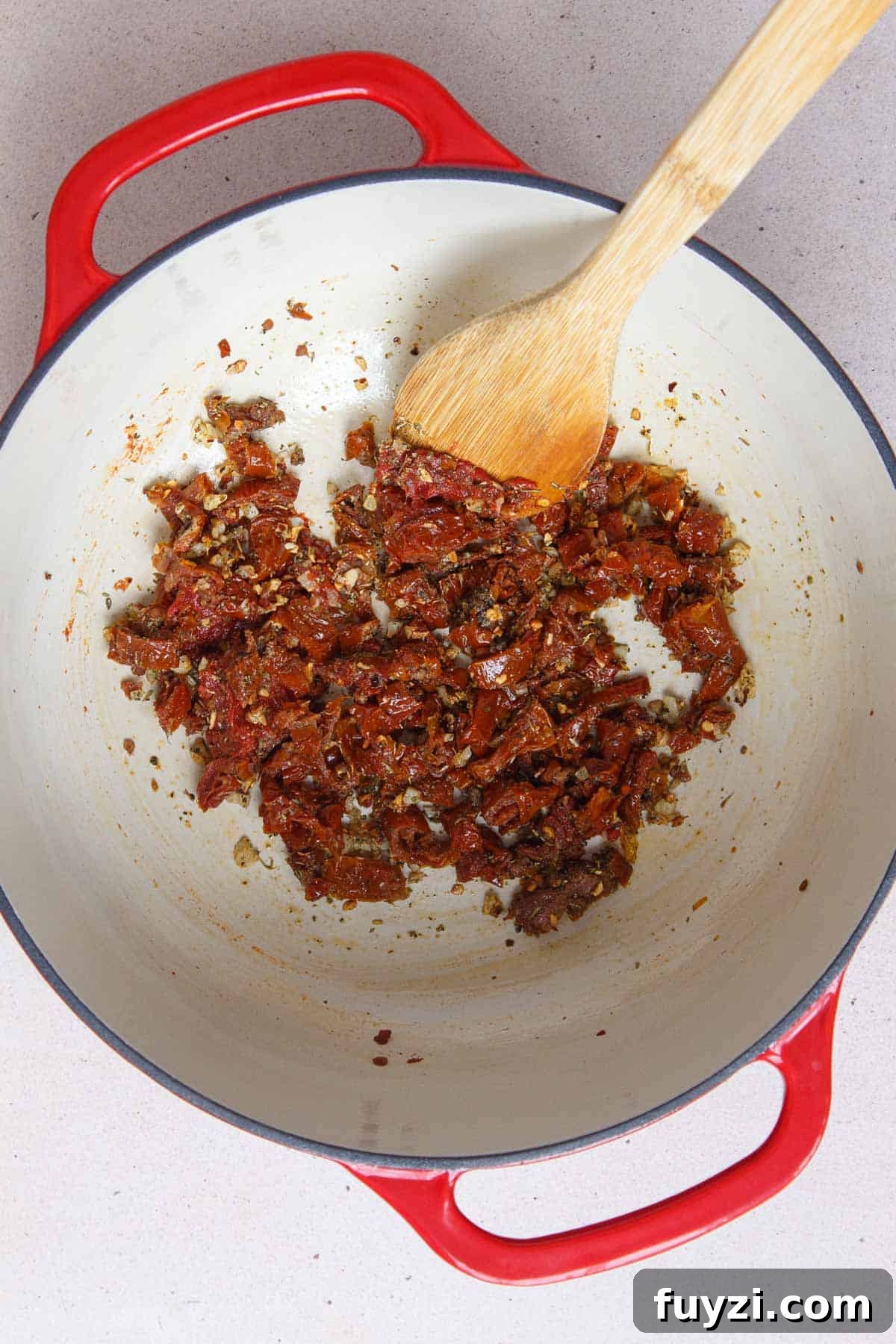 Stirring in the sun-dried tomatoes, tomato paste, and seasonings