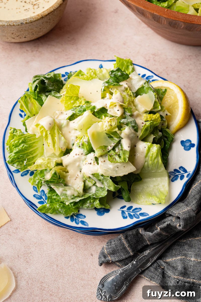 Classic Caesar Salad Recipe with Homemade Dressing 5 Caesar salad on a plate with a lemon wedge for serving.