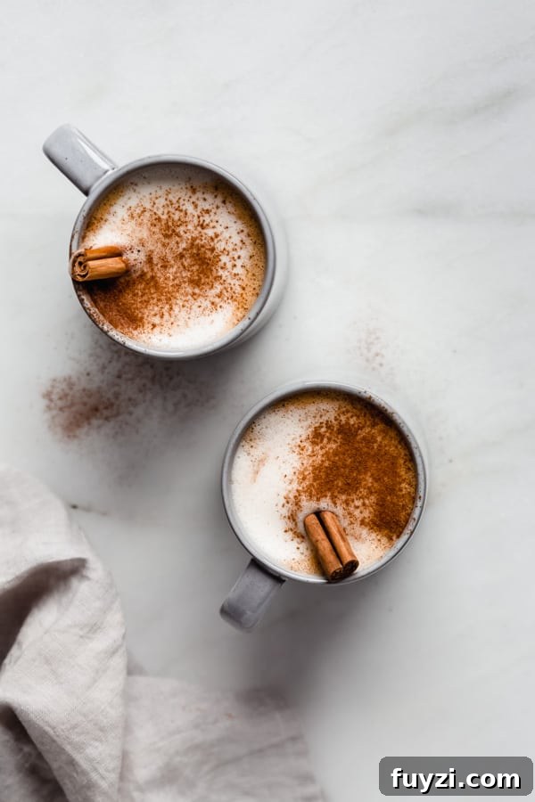 Homemade Vegan Pumpkin Spice Latte Recipe 3 two blue mugs of pumpkin spice latte with cinnamon sticks in them