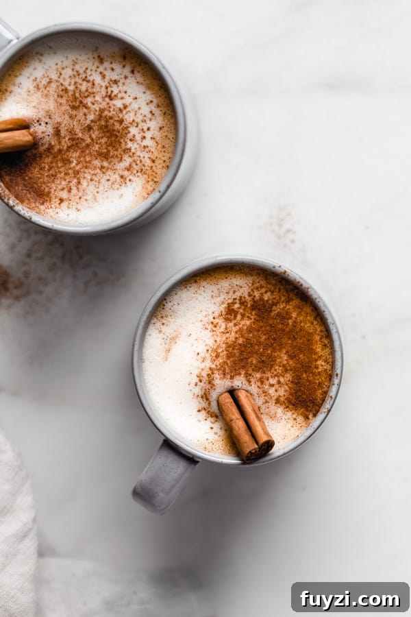 Homemade Vegan Pumpkin Spice Latte Recipe 4 two blue mugs of pumpkin spice latte with cinnamon and cinnamon sticks on top