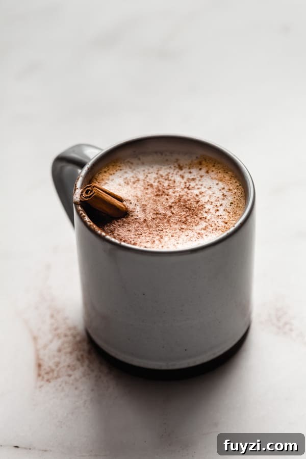 Homemade Vegan Pumpkin Spice Latte Recipe 5 a blue and grey ceramic mug filled with a pumpkin spice latte topped with cinnamon