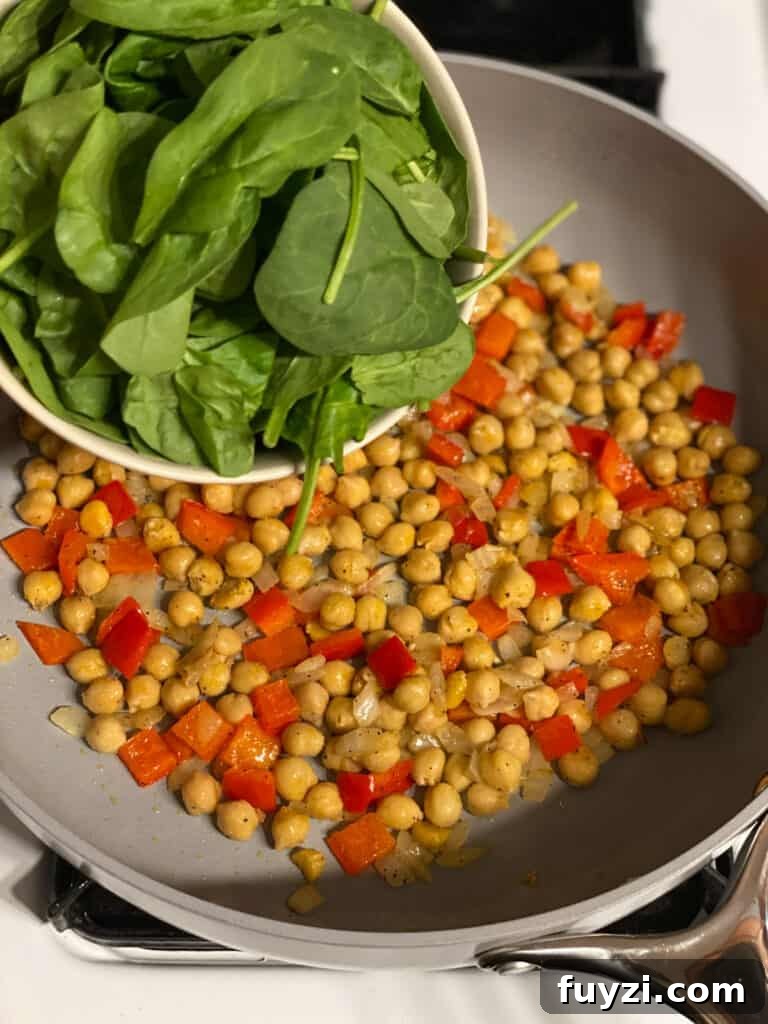 Zesty Vegan Lentil and Chickpea Salad 9 process shot of adding spinach to a pan