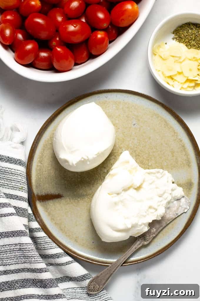 Close up shot of creamy burrata cheese on a gray plate on a white counter top 