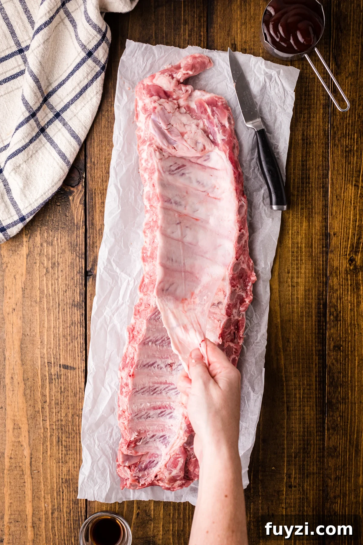 Removing the silver skin from a rack of ribs.