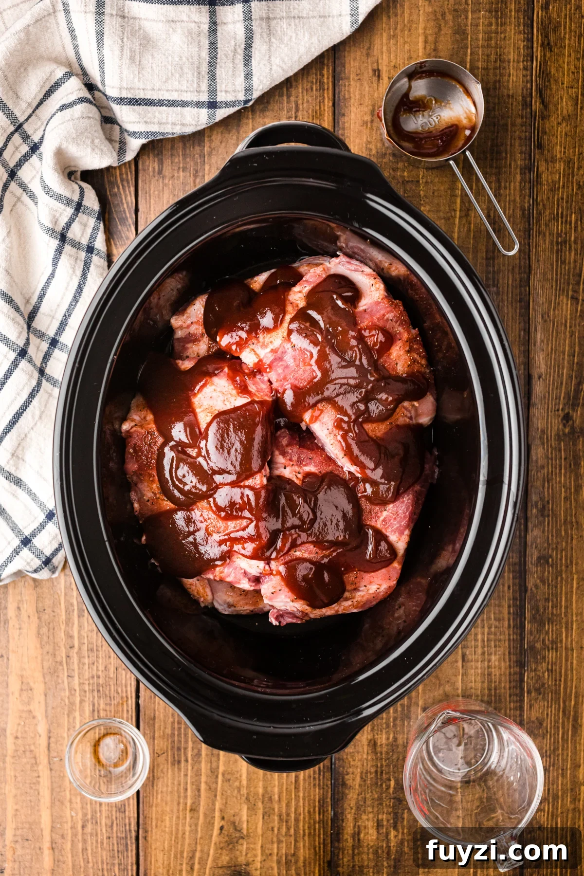 Seasoned ribs, liquid smoke, and bbq sauce in a slow cooker.