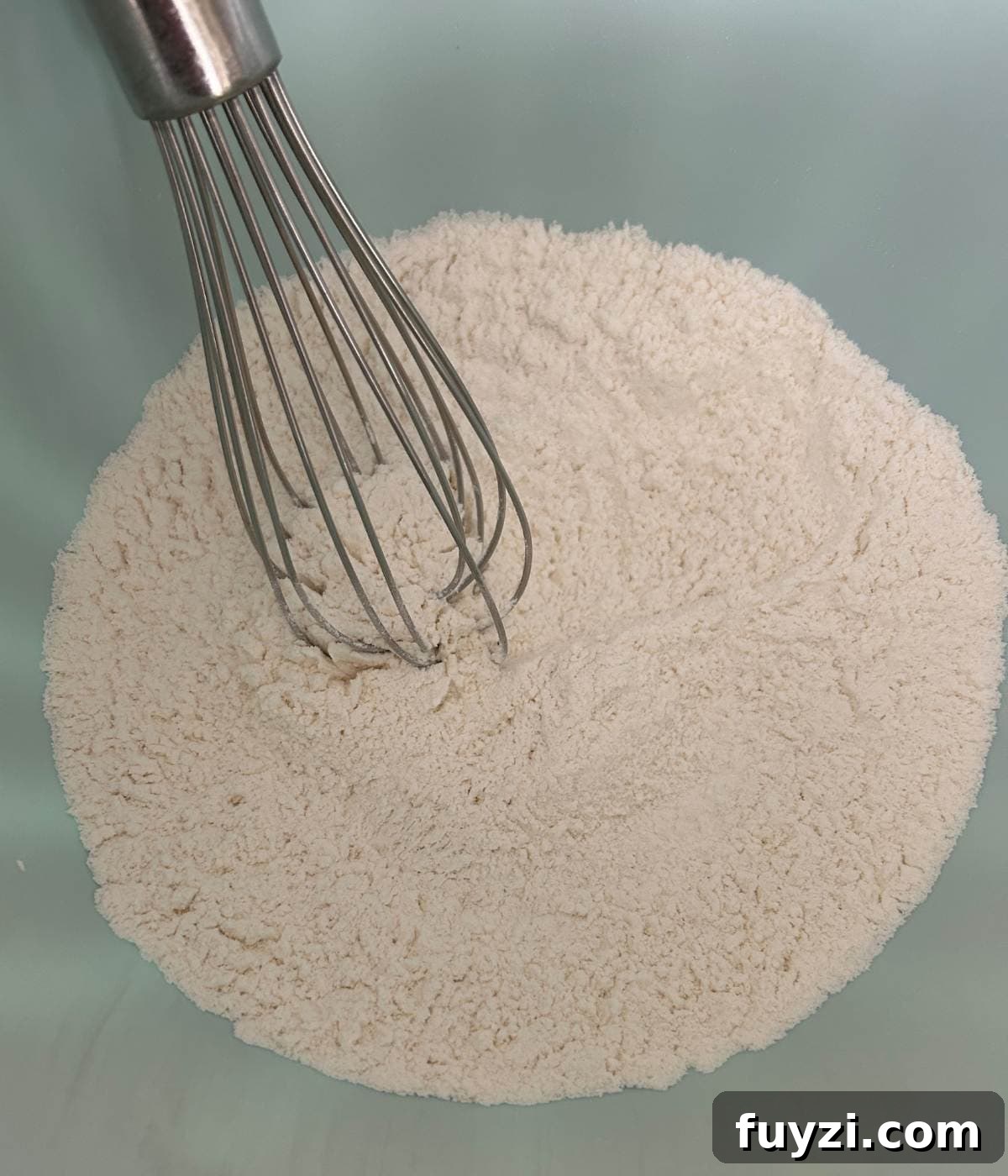 Dry ingredients in bowl with whisk.