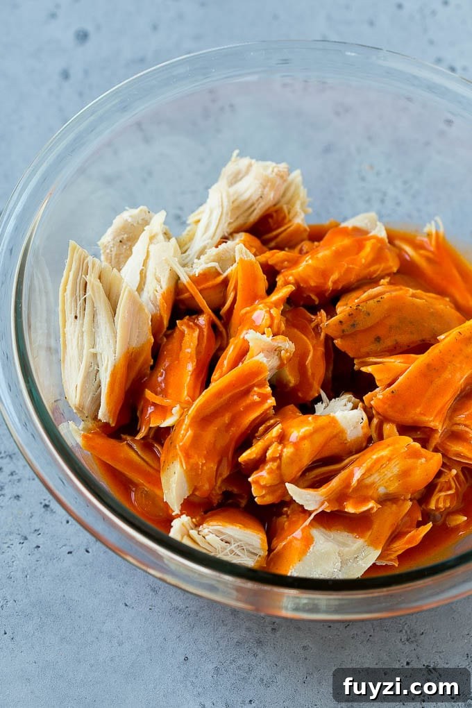 Buffalo Chicken Tacos with Creamy Blue Cheese Slaw 5 Shredded chicken in a bowl drizzled with buffalo sauce.
