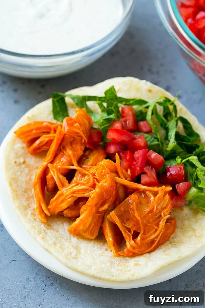 Buffalo Chicken Tacos with Creamy Blue Cheese Slaw 7 Buffalo chicken, tomatoes and shredded lettuce on a tortilla.