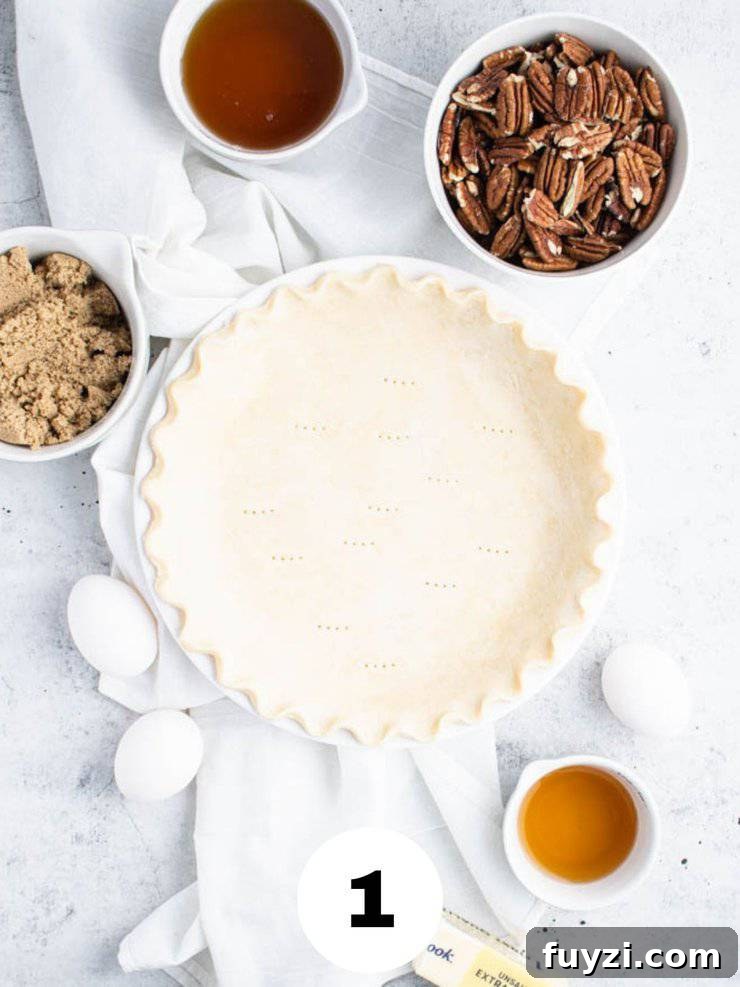 How to Make Bourbon Pecan Pie Without Corn Syrup 3 pie crust in a pie pan next to bowls of agave nectar, halved pecans, brown sugar, bourbon, three eggs and a stick of butter.