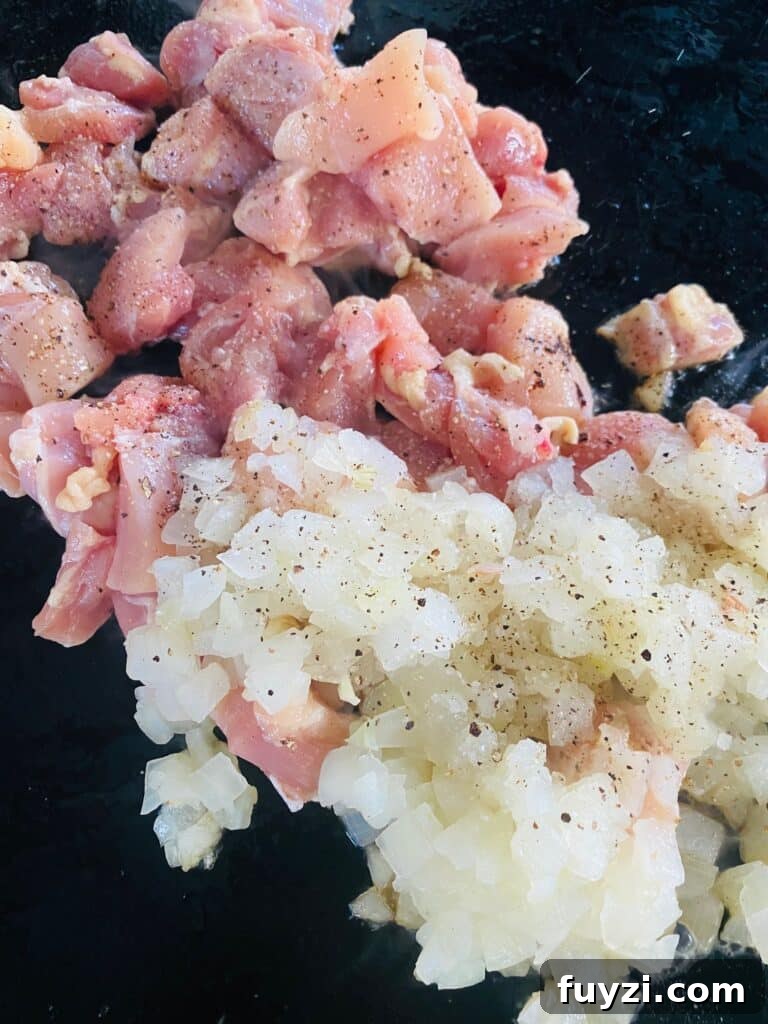 chicken and onions on the griddle before cooking