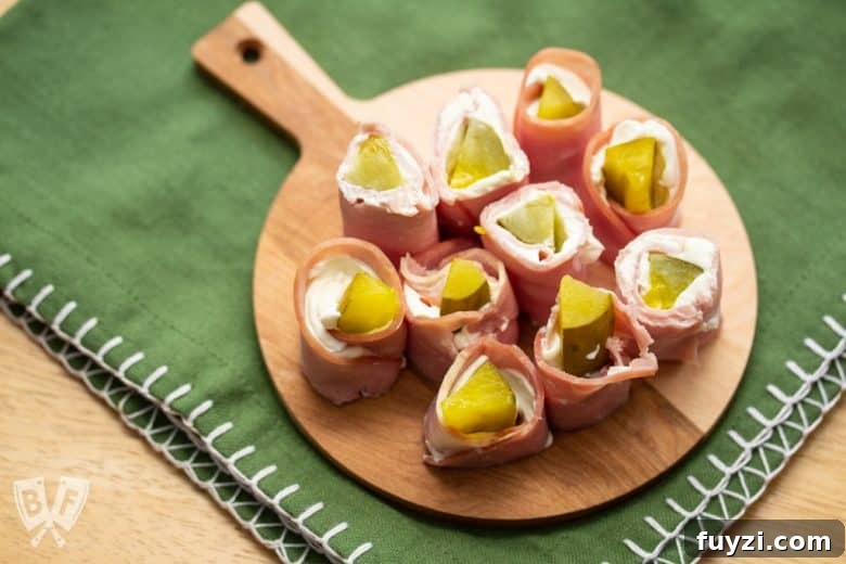 Overhead view of a round board full of pickle treat appetizers.