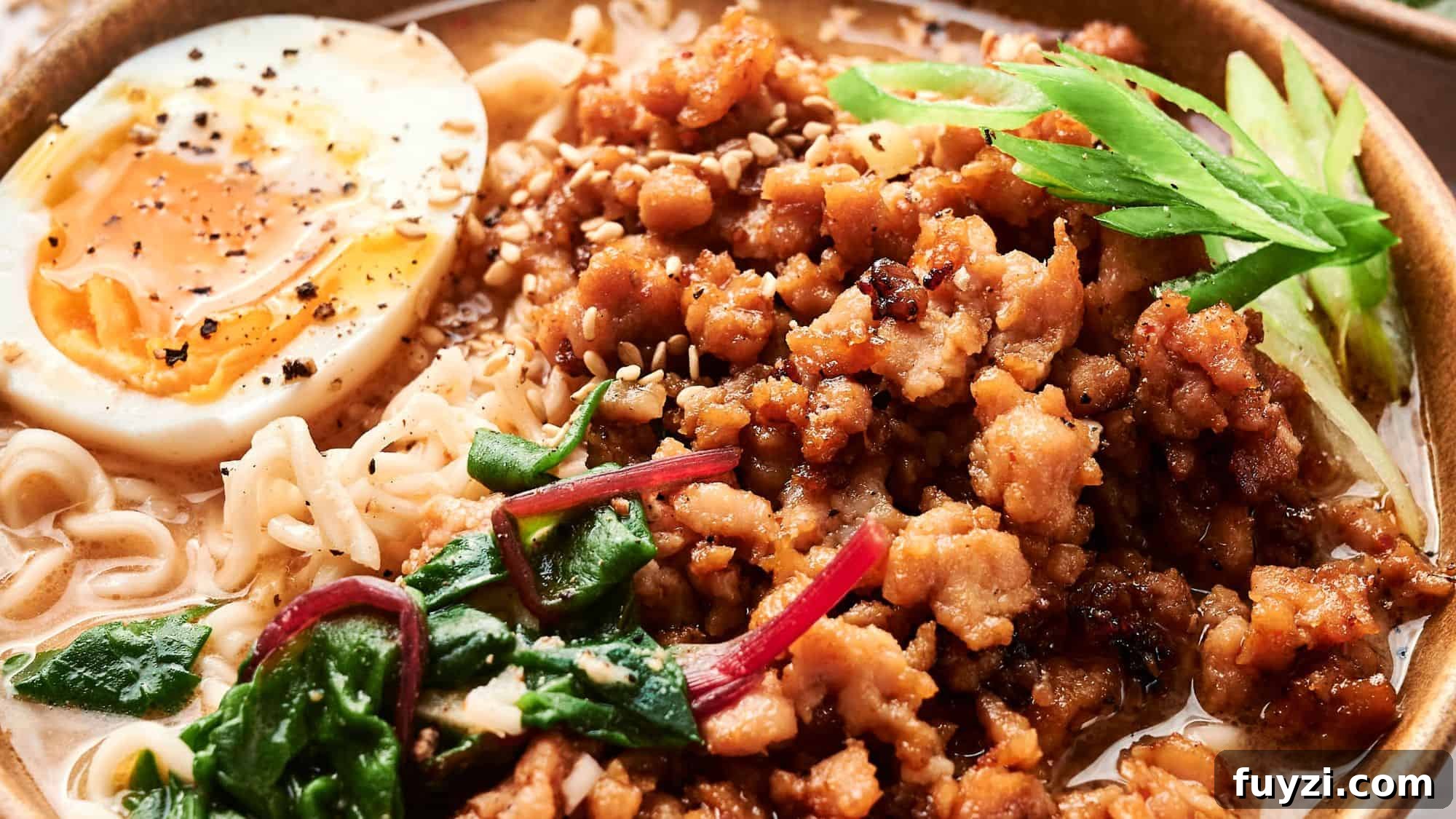 Close-up of a bowl of ramen with minced meat, spinach, sliced scallions, half a soft-boiled egg, and noodles in broth, garnished with sesame seeds and pepper.