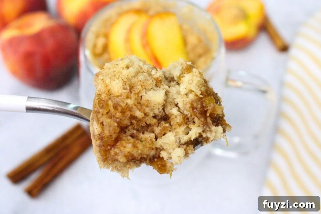 holding up a spoonful of microwave peach mug cake