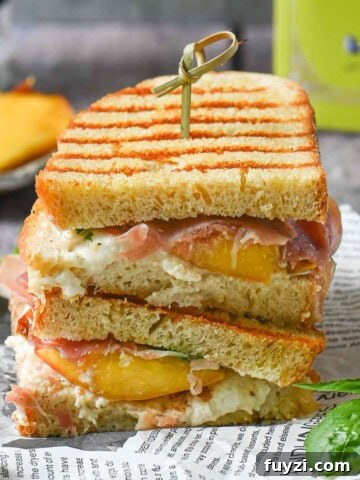 Gorgonzola and Pear Grilled Cheese Recipe with Jam 11 Peach panini stacked on deli paper with basil and peaches in the background.