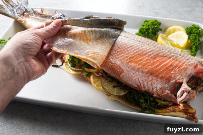 Grill a Whole Salmon: Step-by-Step Guide 7 Removing the skin from a cooked salmon.