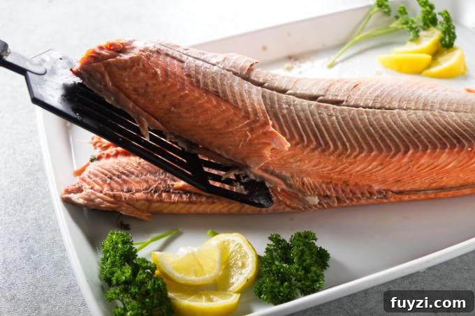 Grill a Whole Salmon: Step-by-Step Guide 8 A whole cooked salmon being carved and de-boned.