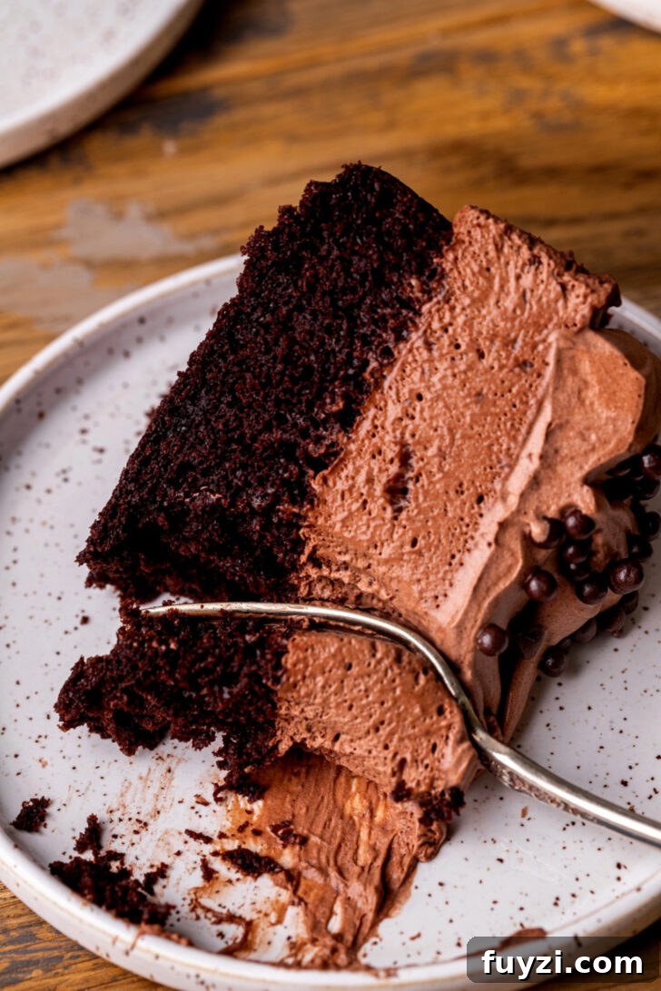 Fork inserted into a slice of cake.