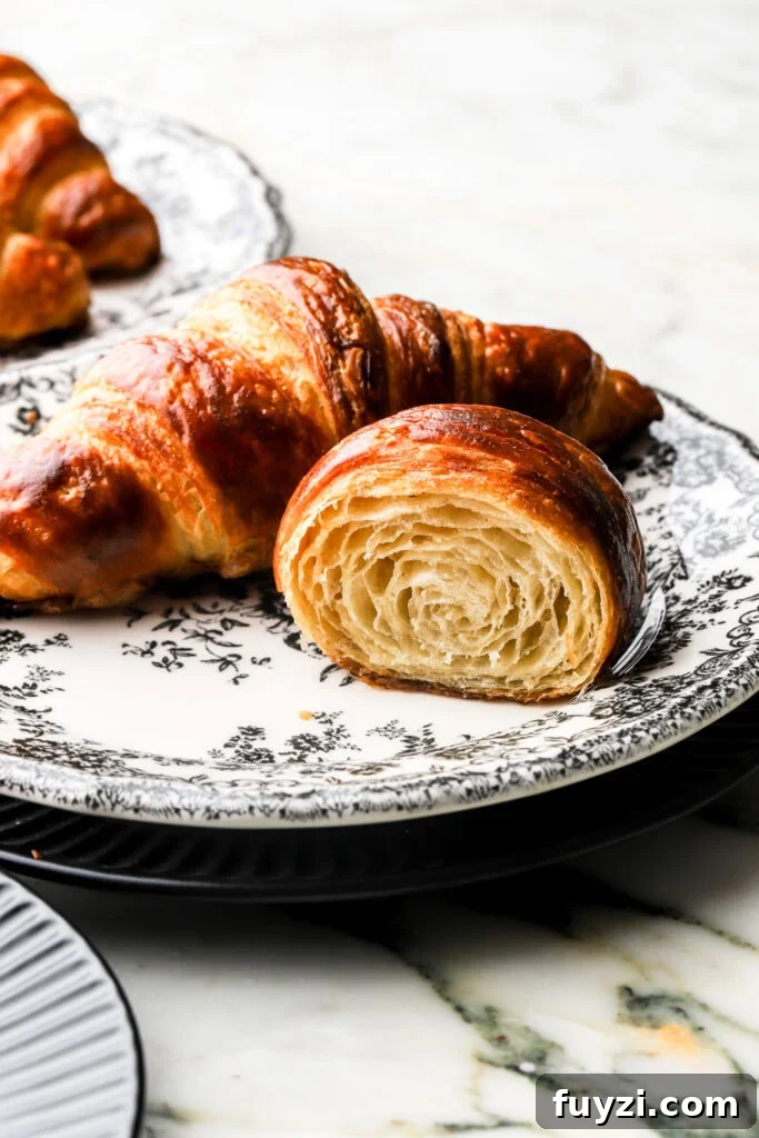 How to Make Flaky Homemade Croissants: French Recipe 16 croissant cut in half to show inside, on a plate