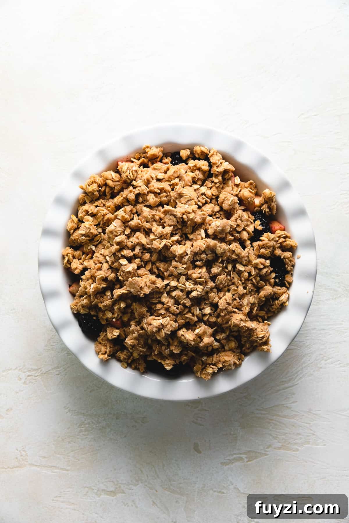Top down view of crumble topping on fruit.