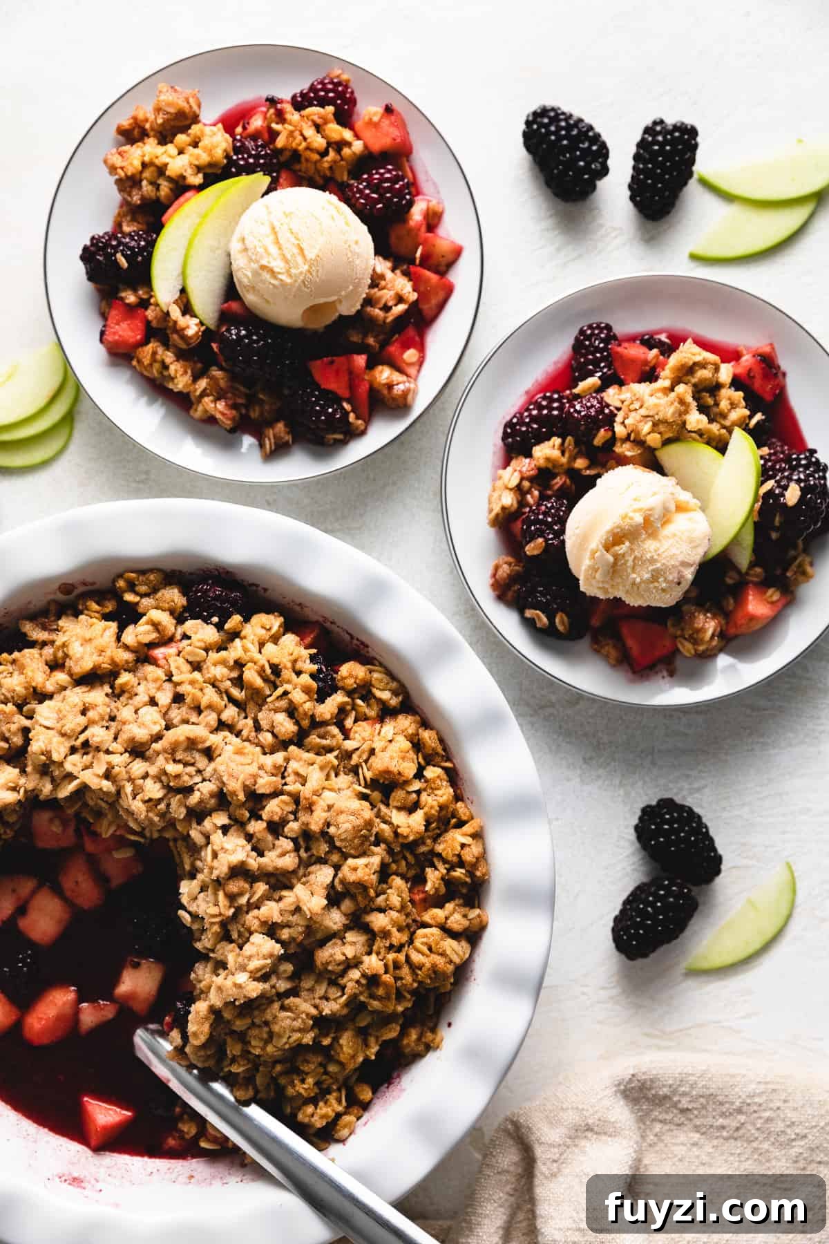 Top down view of plates of apple and blackberry crumble.