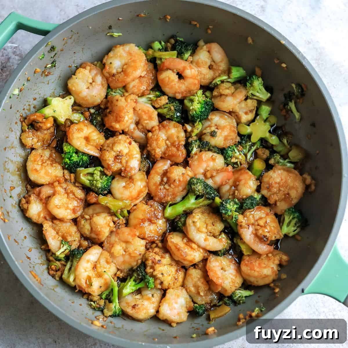Grey skillet with Mongolian shrimp and broccoli.