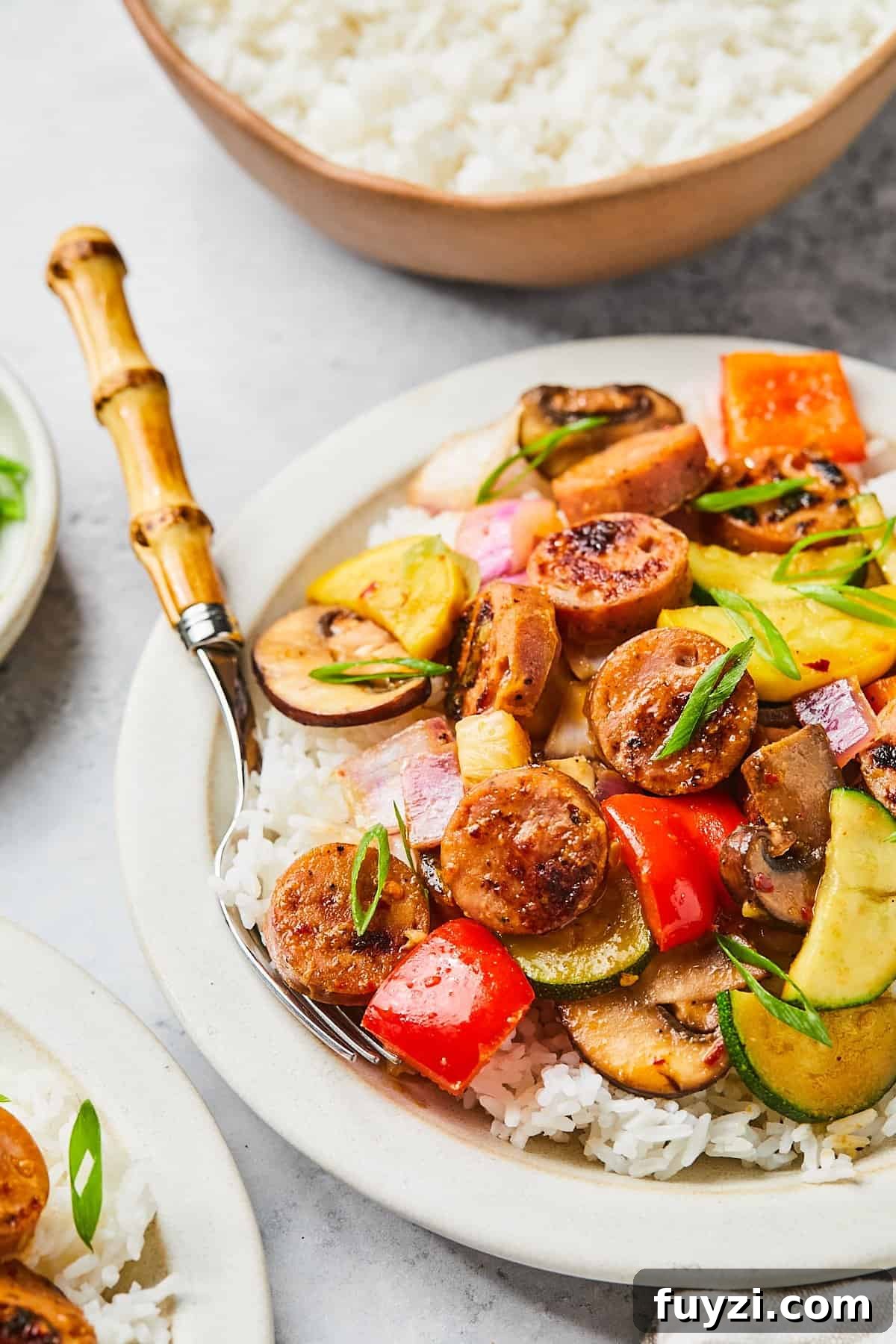 Skillet Chicken and Apple Sausage Stir Fry Recipe 12 Serving of sausage stir fry in a bowl with white rice and chopped green onions