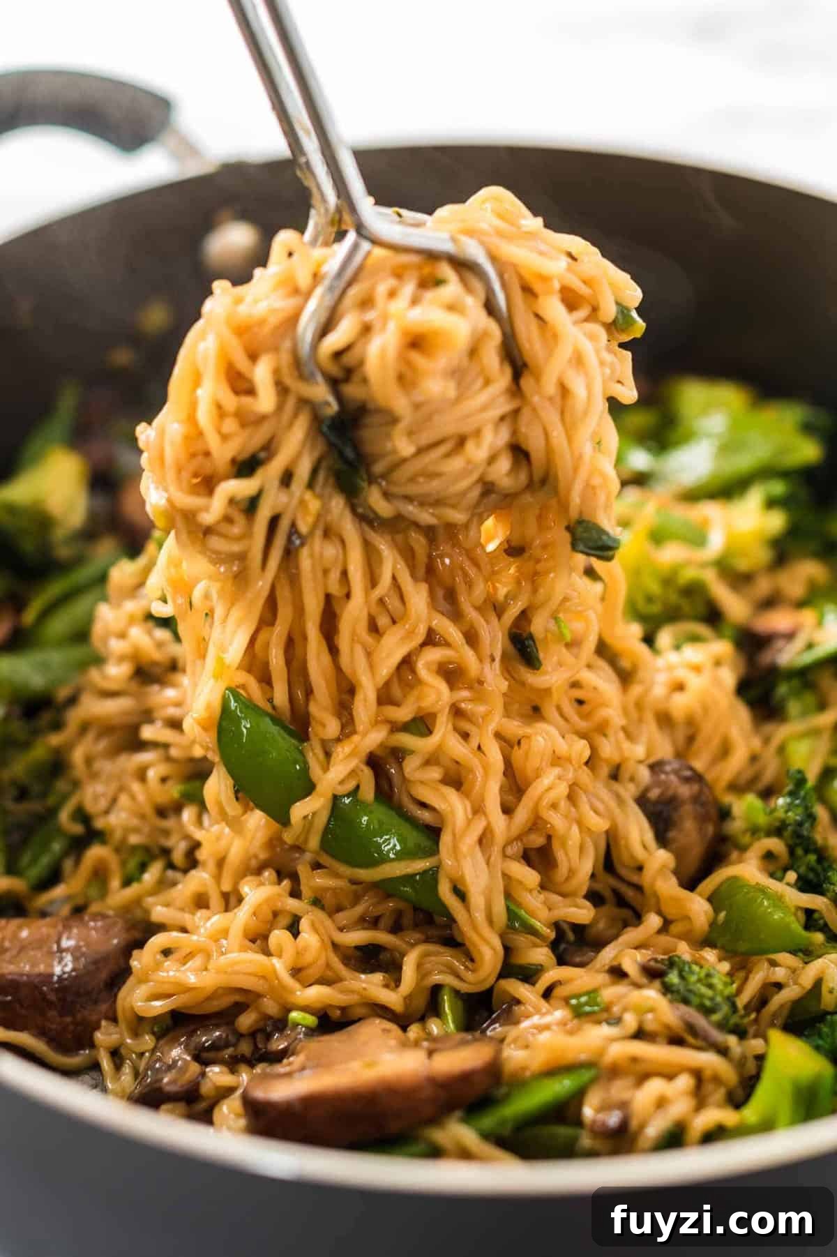 grabbing a serving of teriyaki noodles