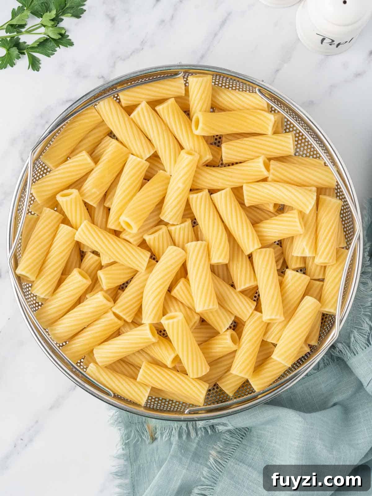 Creamy Tuna Pasta Bake with Crispy Cheesy Crust 4 Cooked noodles in a colander.