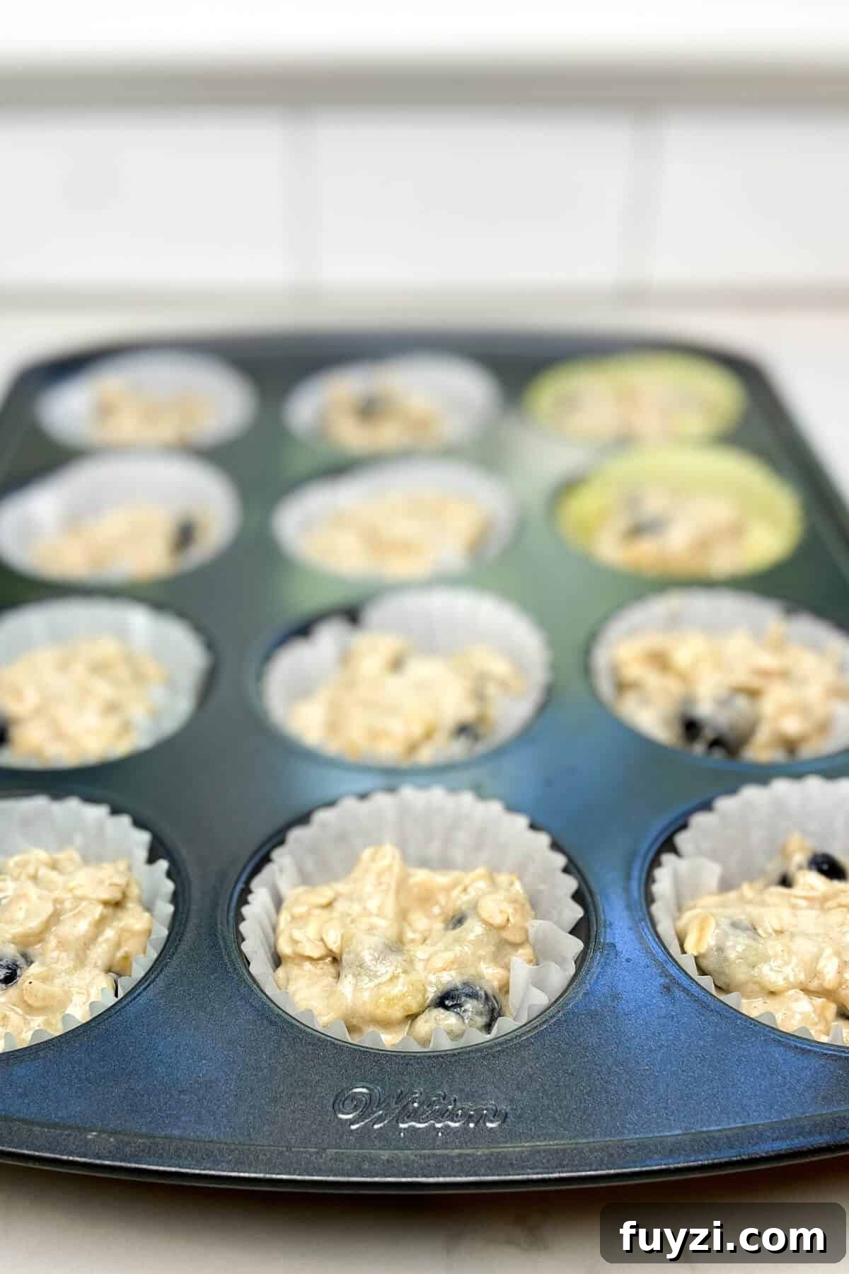 Batter in lined muffin tin.
