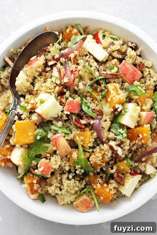 Apple Quinoa Salad A white dish filled with Apple Quinoa Salad and a serving spoon.