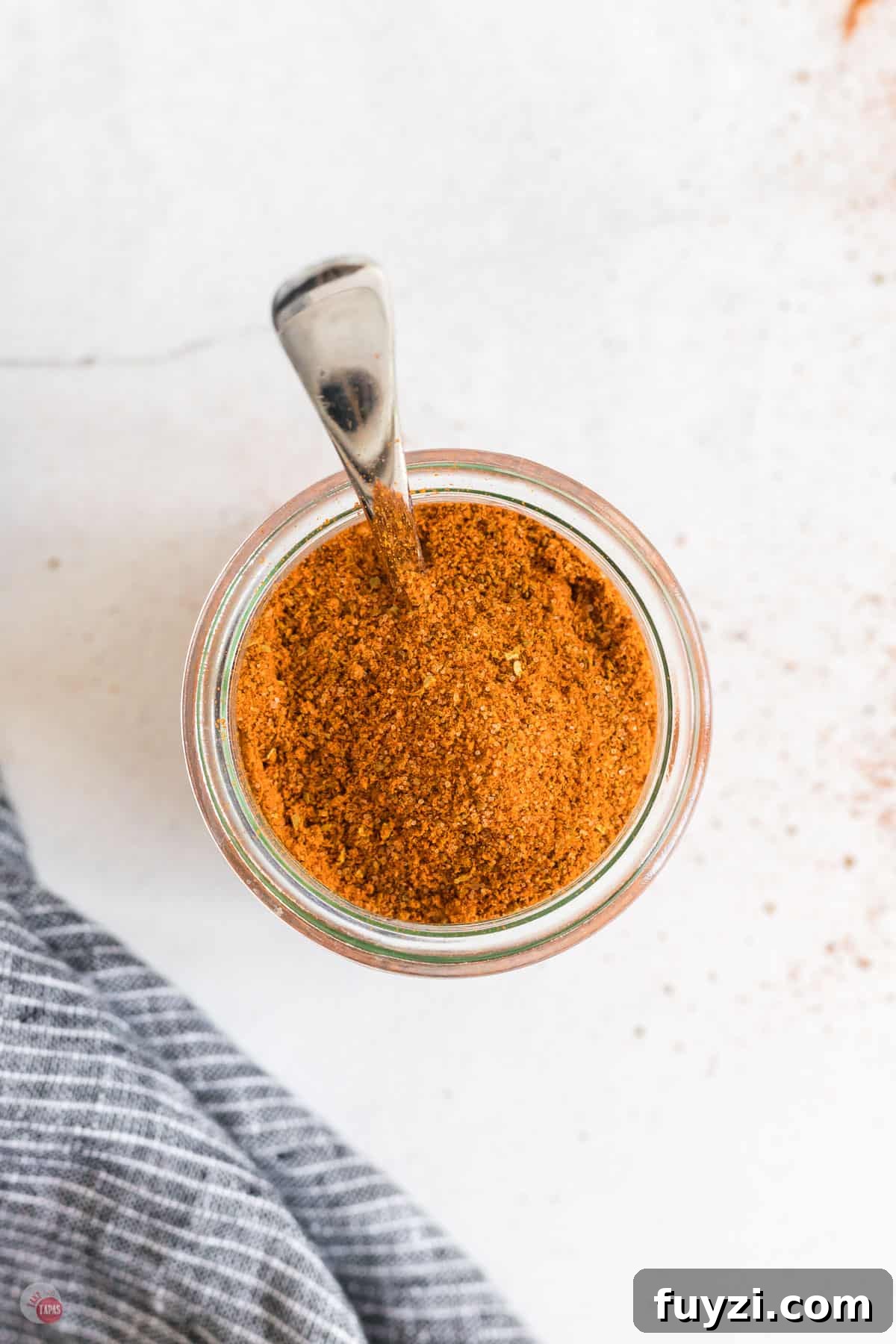 jar of old bay seasoning with a spoon