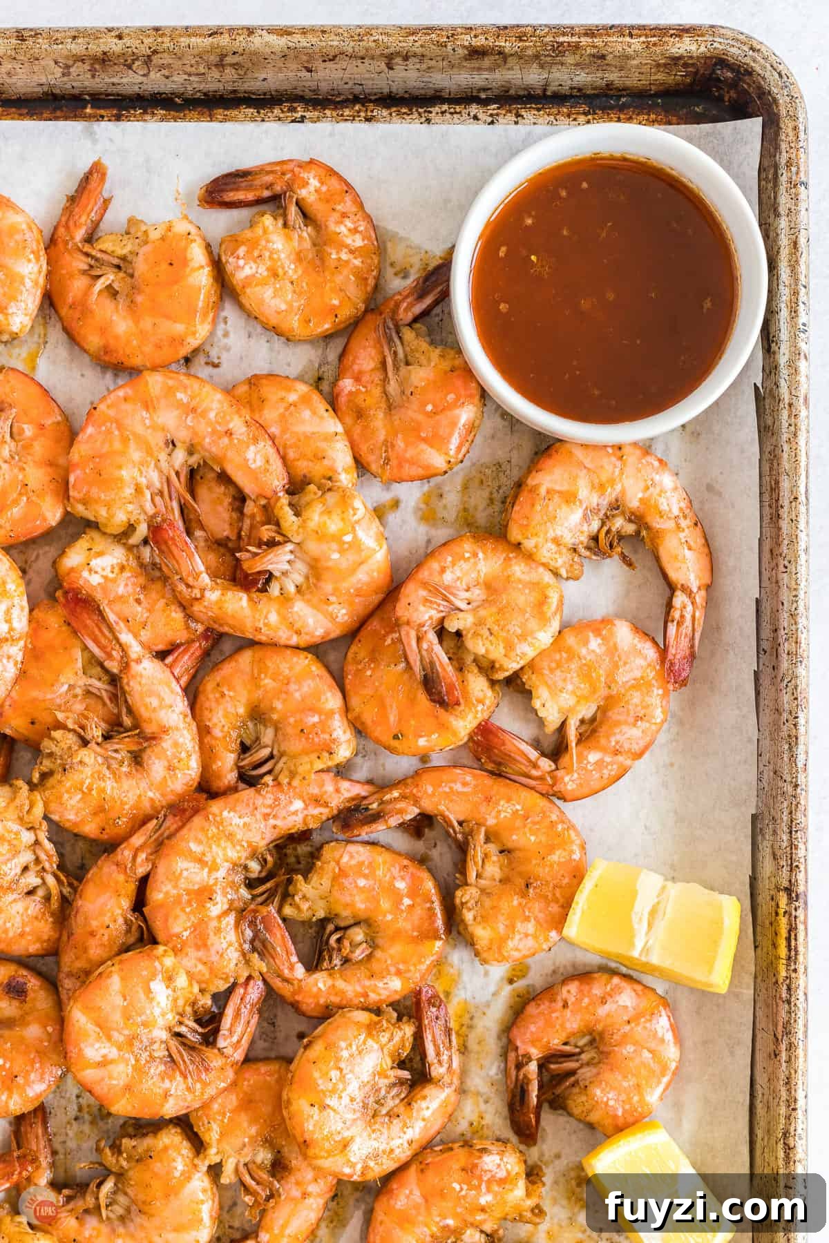 sheet pan of shrimp with bowl of spiced butter