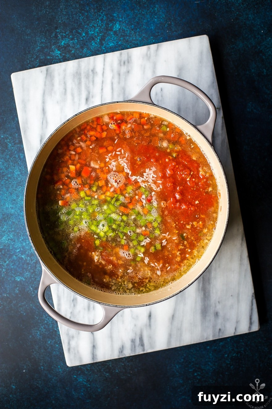 Overhead photo of precooked stuffed pepper soup in a pot on a marble board