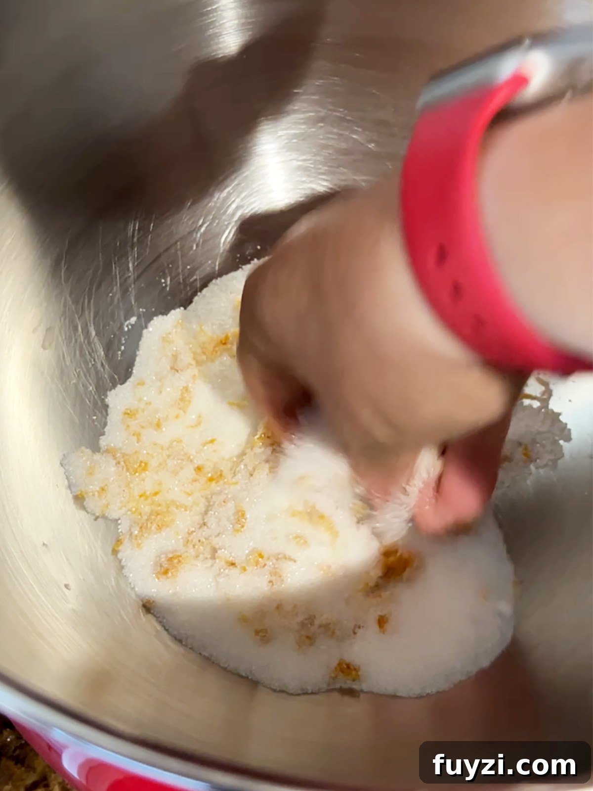 Mixing orange zest and sugar in stand mixer bowl for cranberry orange shortbread dough.