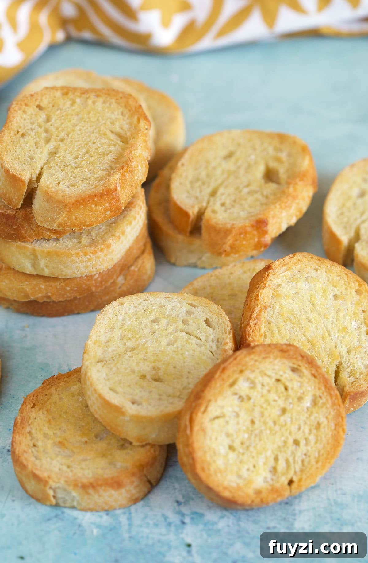 How to Make Crostini: Crispy Homemade Bread and Topping Ideas 2 Slices of crostini are placed on a light blue surface.