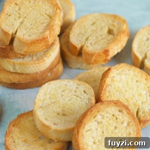 Slices of crostini are placed on a light blue surface.