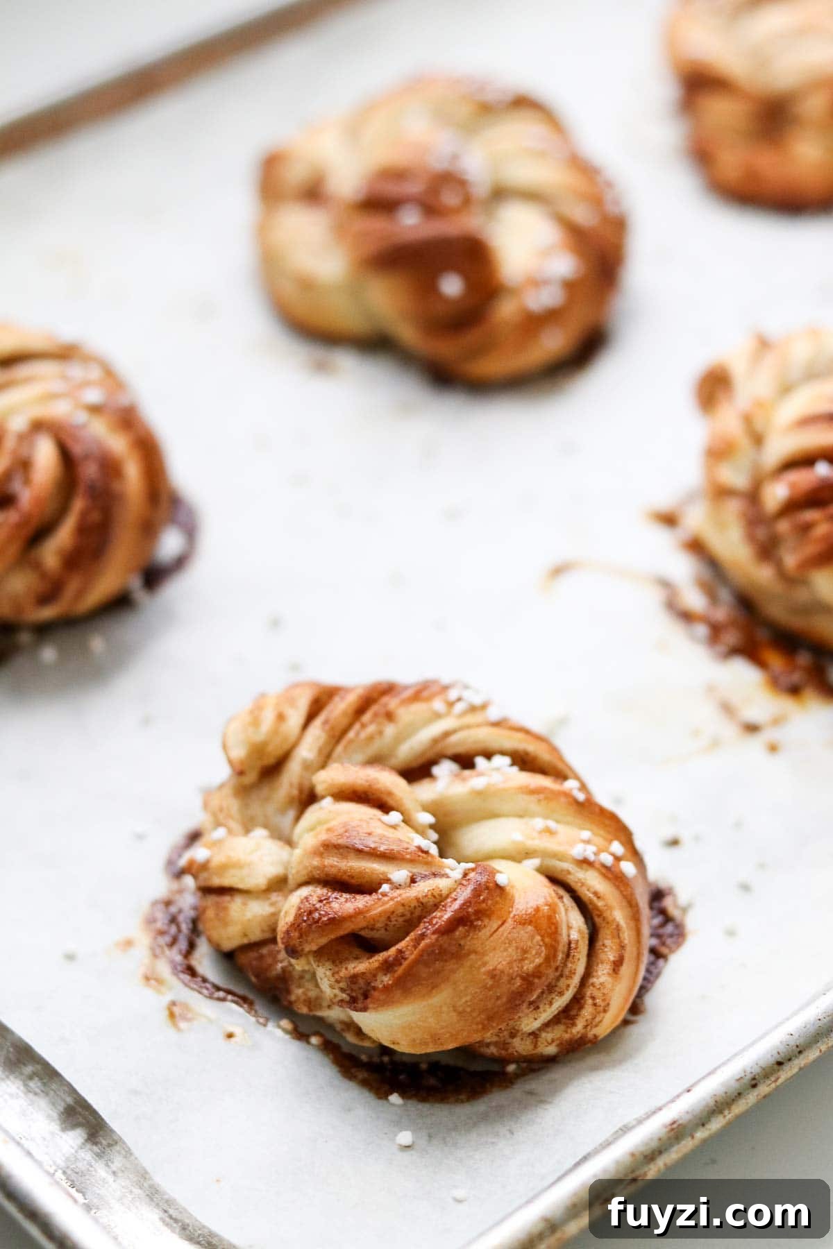 Baked Swedish Cinnamon Buns (Kanelbullar) on a baking sheet.
