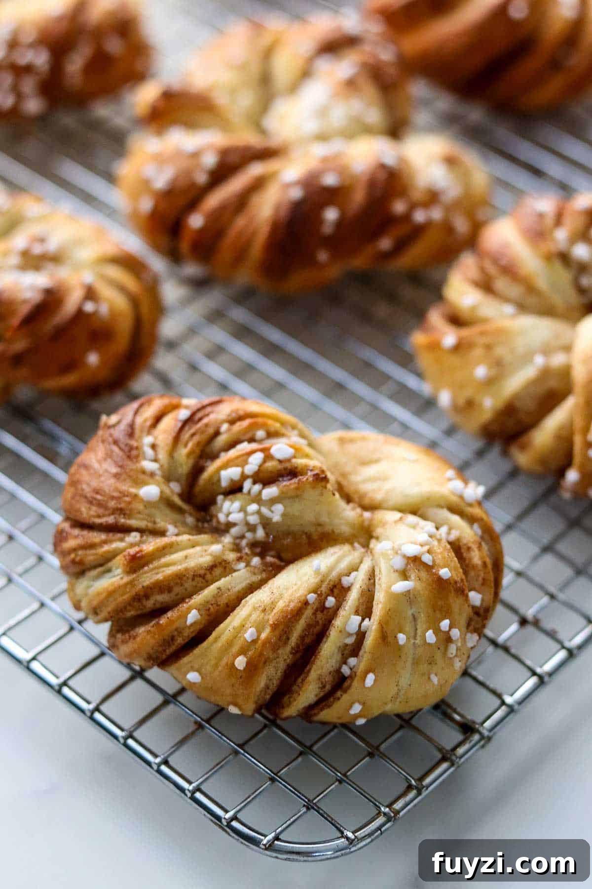 Swedish Cinnamon Buns (Kanelbullar) on a metal cooling rack.