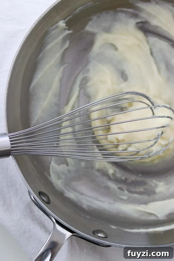 Tangzhong in a metal saucepan with a whisk.