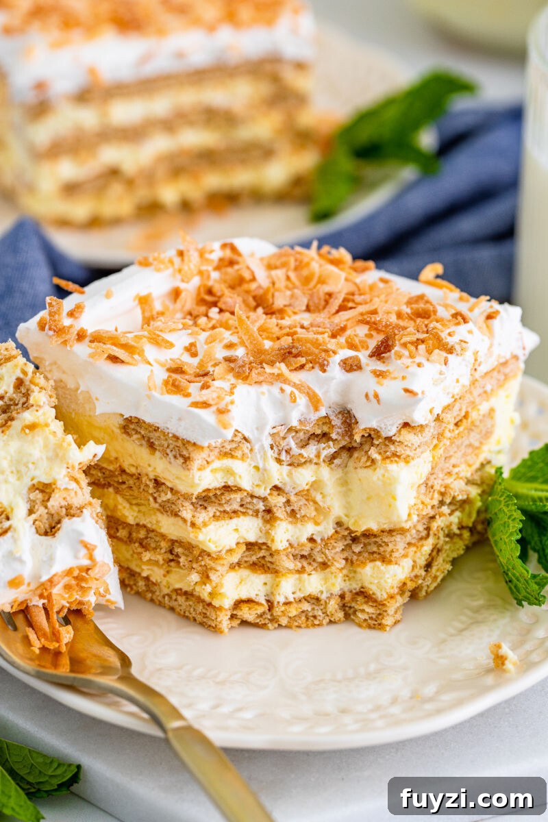 bite of coconut icebox cake on a fork resting on the plate next to the slice