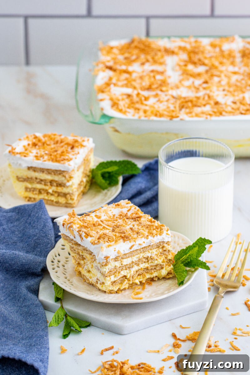 two slices of coconut icebox cake on plates next to the dish