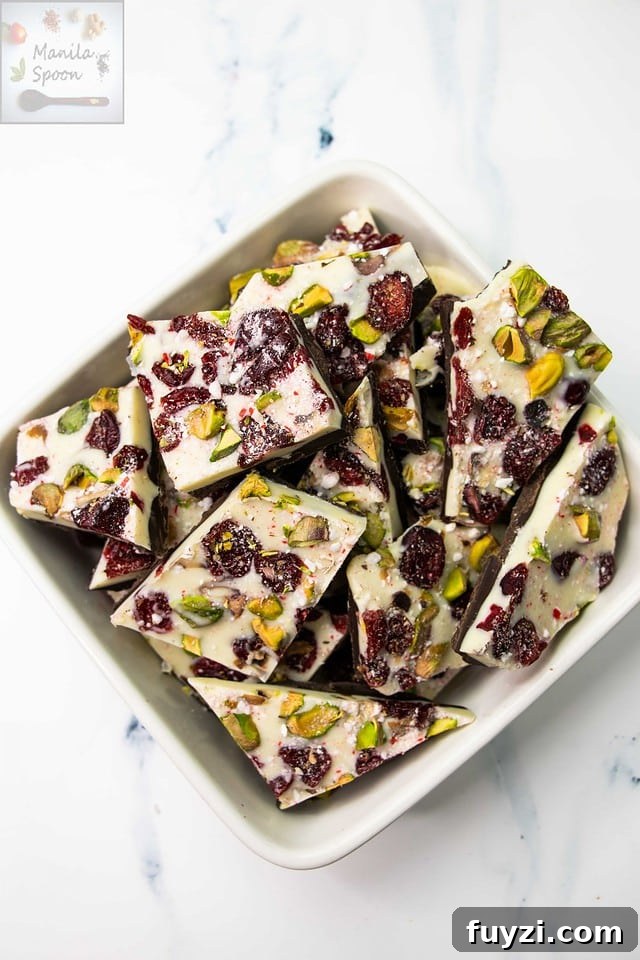 With a layer of dark and white chocolate and dotted all over with red cranberries and green pistachios, this gorgeous double chocolate bark is the ultimate holiday candy! So easy to make and the taste is simply outstanding! Make the holidays special with this Easy Double Chocolate Bark with Cranberries and Pistachios! Featuring layers of rich dark and creamy white chocolate topped with festive red cranberries and green pistachios, this quick and stunning candy is as delicious as it is beautiful!