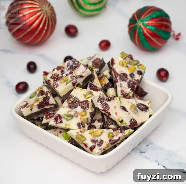 With a layer of dark and white chocolate and dotted all over with red cranberries and green pistachios, this gorgeous double chocolate bark is the ultimate holiday candy! So easy to make and the taste is simply outstanding! Make the holidays special with this Easy Double Chocolate Bark with Cranberries and Pistachios! Featuring layers of rich dark and creamy white chocolate topped with festive red cranberries and green pistachios, this quick and stunning candy is as delicious as it is beautiful!